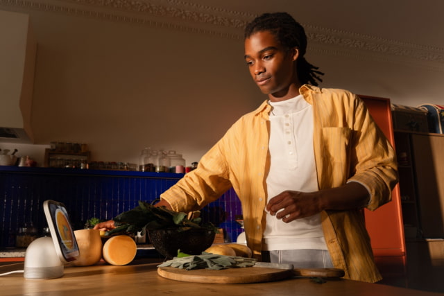 A person cooking in their kitchen looks at HomeView.